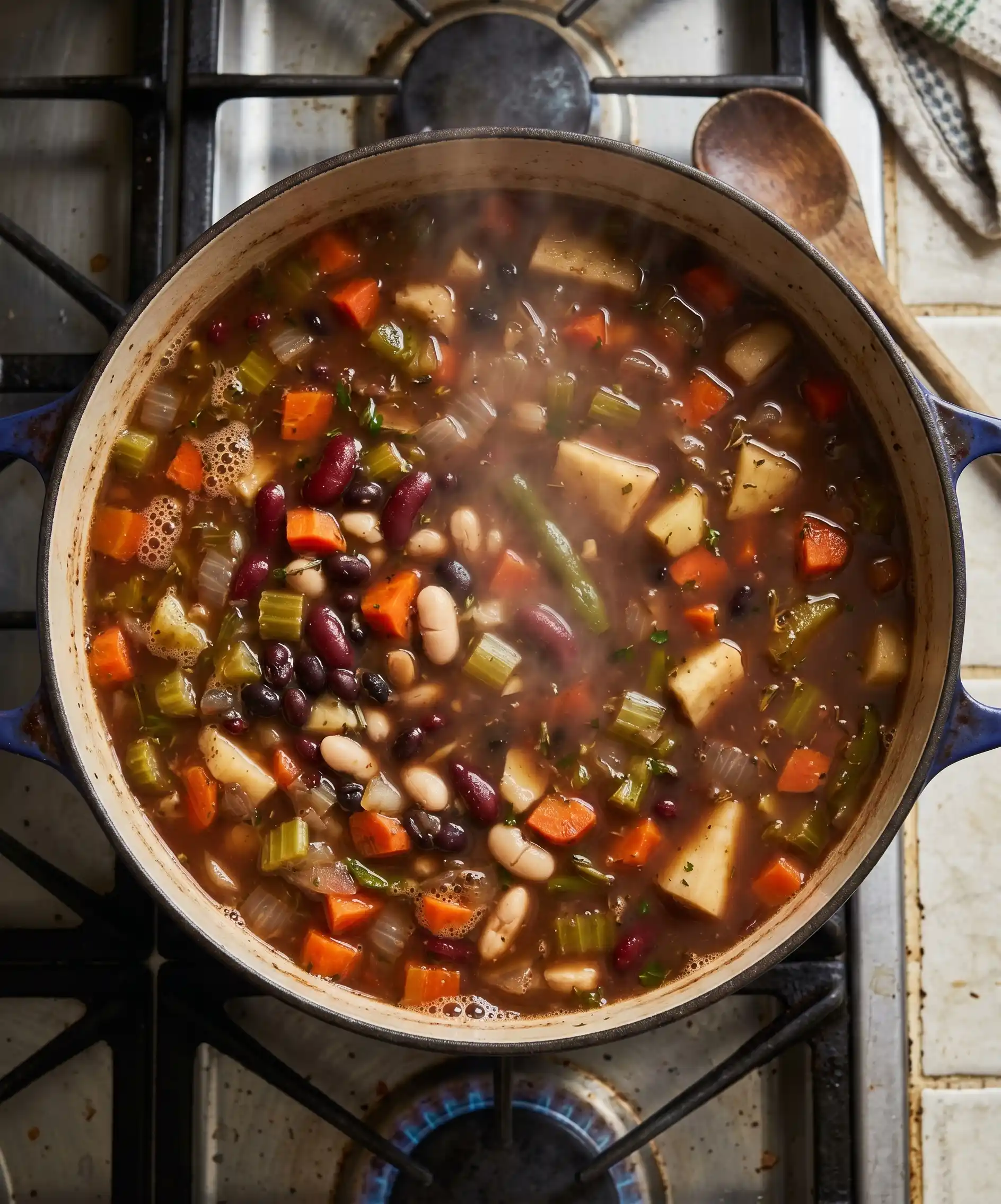 A top-down shot of a large pot of hearty homemade vegetable and bean soup simmering on a stovetop &mdash; rustic, steam rising, vegetables and beans visible through a rich broth &mdash; warm, nourishing, and deeply nostalgic.